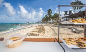 a table with a plate of food on the beach at Hotel Decameron Maryland All Inclusive in San Andrés