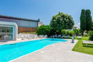 - une piscine dans une cour avec des chaises longues dans l'établissement B & b Venere, à Paestum