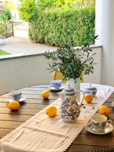 een tafel met sinaasappels en bekers en een vaas erop bij Apartman Marina Veruda in Pula