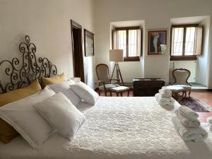 um quarto com uma cama branca e toalhas em Residenza Villa Degli Ochi em Sagginale