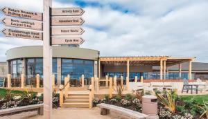 un cartel con flechas delante de un edificio en 16 Gannet Grove Thornwickbay. Haven site, en Flamborough