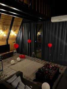 Gohali Bungalov في طرابزون: غرفة معيشة مع بالونات حمراء وطاولة