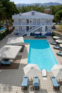 プリノスにあるKazaviti Hotelのスイミングプール、椅子、パラソルを提供しています。