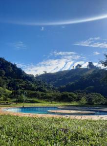 a swimming pool with a view of a mountain at Rancho Maria Pimenta in Joanópolis