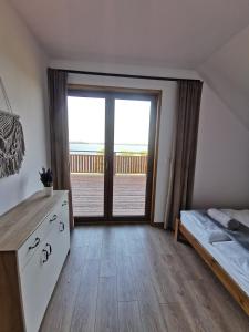 ein Schlafzimmer mit einem Bett und einem großen Fenster in der Unterkunft Mazurski Horyzont in Leleszki