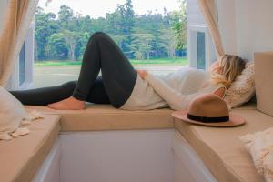 a woman laying on a window swing with a hat at Campervan Bogota Rolling Suite in Bogotá