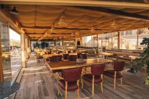a restaurant with wooden tables and chairs and windows at Hu of Cappadocia - Special Class in Uçhisar