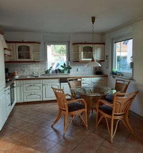 a kitchen with a table and chairs in a kitchen at Ferienhaus am Kulkwitzer See in Leipzig