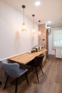 comedor con mesa de madera y 2 sillas en NEW Iorga2 OldCity SelfCheckIn, en Timisoara