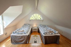 two beds in a attic room with a window at 2 Bed House Sleeps 4 with Garden & Free Parking in Ronneby