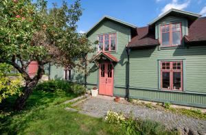 una casa verde con puerta roja en Modern house in Ronneby near lake and sea, en Ronneby