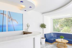 a living room with a blue couch and a window at Kazaviti Hotel in Prinos