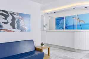 un soggiorno con divano blu e un dipinto di Kazaviti Hotel a Prinos