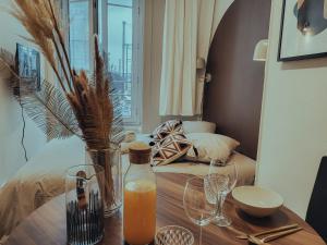 - une table avec une bouteille de jus d'orange et des verres dans l'établissement Suite Abysse, à Lyon