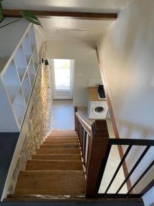 Eine Treppe führt zu einem Zimmer mit einer Waschmaschine. in der Unterkunft Belle vue in Saint-Silvain-Bas-le-Roc