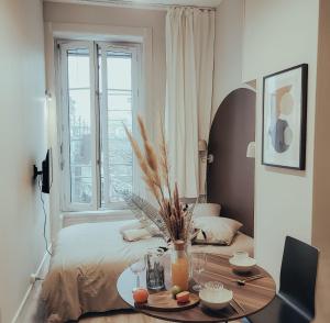 - une chambre avec une table et un lit avec une fenêtre dans l'établissement Suite Abysse, à Lyon