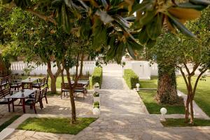 eine Terrasse mit Tischen, Stühlen und Bäumen in der Unterkunft Kazaviti Hotel in Prinos