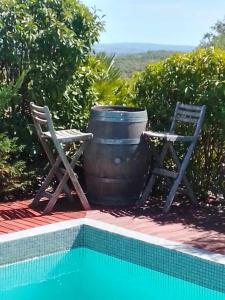 a barrel and two chairs next to a swimming pool at Villa avec une piscine privée in Quarante