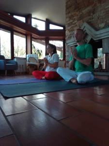 dos personas sentadas en el suelo en una habitación haciendo yoga en Villa avec une piscine privée, en Quarante