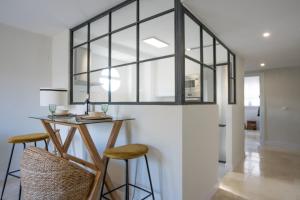 a dining room with a table and two stools at Luxury Apartment Free Parking in Seville