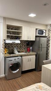 a kitchen with a washing machine and a refrigerator at Flat in Brasilia