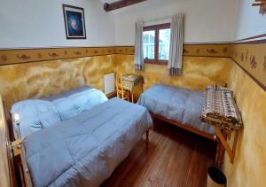 a bedroom with two beds and a table and a window at Tradicion Colca in Yanque