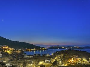 a view of a city and a lake at night at Eirini Luxury Hotel Villas in Grikos