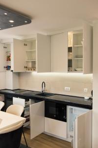 a kitchen with white cabinets and a black counter top at Apartman BATI - Ravna Planina in Pale