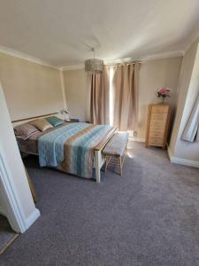 a bedroom with a bed and a chair and a dresser at Number One Bridgefoot Cottage in West Stockwith