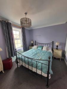 a bedroom with a bed and a chandelier at Number One Bridgefoot Cottage in West Stockwith