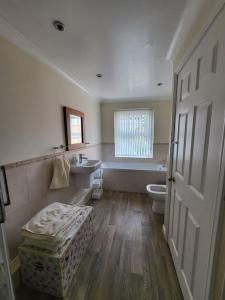 a bathroom with a toilet and a sink and a tub at Number One Bridgefoot Cottage in West Stockwith