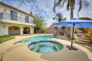 an umbrella next to a swimming pool with a house at Luxe Yuma Home with Private Pool! in Yuma