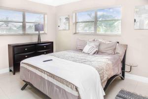 een slaapkamer met een bed, een dressoir en 2 ramen bij Miami 3BR Cozy Home w/ Spacious Yard in Miami