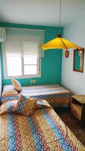 リンコン・デ・ラ・ビクトリアにあるLa Casita de Nuriaのベッド2台と黄色い傘が備わる客室です。