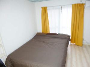 1 dormitorio con 1 cama y una ventana con cortinas amarillas en The Mickey Carlton Ohashi Alpha Coat - Vacation STAY 15163 en Fukuoka