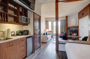 a kitchen with a sink and a living room at Estrimont in Magog-Orford