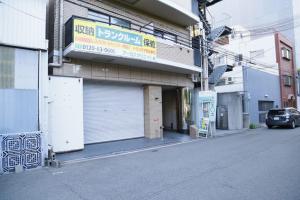 une voiture garée devant un immeuble avec garage dans l'établissement Precioso Umeda - Vacation STAY 15185, à Osaka