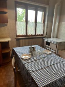 a kitchen with a table with a blue and white checkered table cloth at B&B PRETITE in Artegna