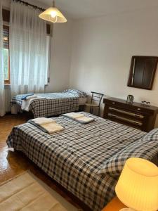 a bedroom with two beds and a desk and a tv at B&B PRETITE in Artegna