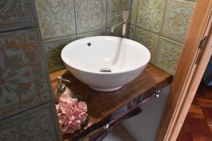 a bathroom with a white bowl sink on a wooden counter at Vale dos Ilhéus in Machico