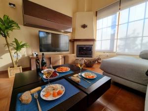 a living room with a table with food and wine glasses at Un Chalecito en Cantabria in Periedo