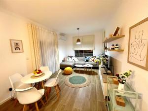 a living room with a couch and a table and chairs at Caruso apartment in Tivat