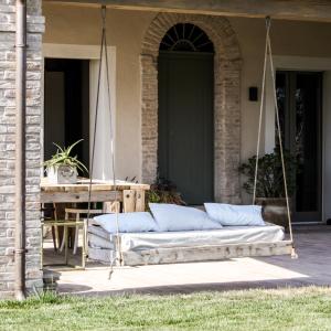 a porch swing with pillows on a house at Bnb Verdeolivo in Coriano