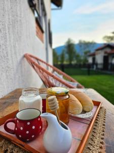 a tray with a cup of tea and bread on a table at Rooms Vukša in Donji Lapac