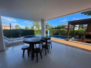 un patio con tavolo e sedie e una piscina di Casa Grande Angra de Ipioca Hibiscus a Paripueira