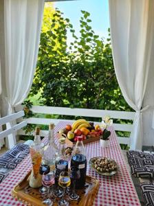 una mesa de picnic con una bandeja de frutas y botellas de vino en Rooms Vukša, en Donji Lapac