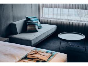 Cette chambre comprend un lit, un canapé et une table. dans l'établissement THE BOLY OSAKA - Vacation STAY 52787v, à Osaka