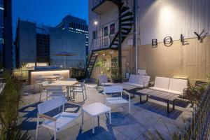 un patio avec des tables et des chaises blanches et un bâtiment dans l'établissement THE BOLY OSAKA - Vacation STAY 52787v, à Osaka