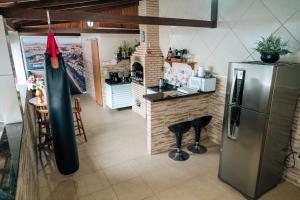 una cocina con nevera de acero inoxidable y un bar en APTO - Espaço Único Vix, en Vitória