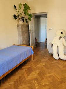a bedroom with a large teddy bear sitting on a bed at Apartament Salwator Fałata in Krakow